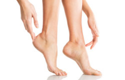 Closeup shot of a woman applying moisturizer to her leg and feet