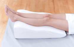 woman's legs lay down on a pillow